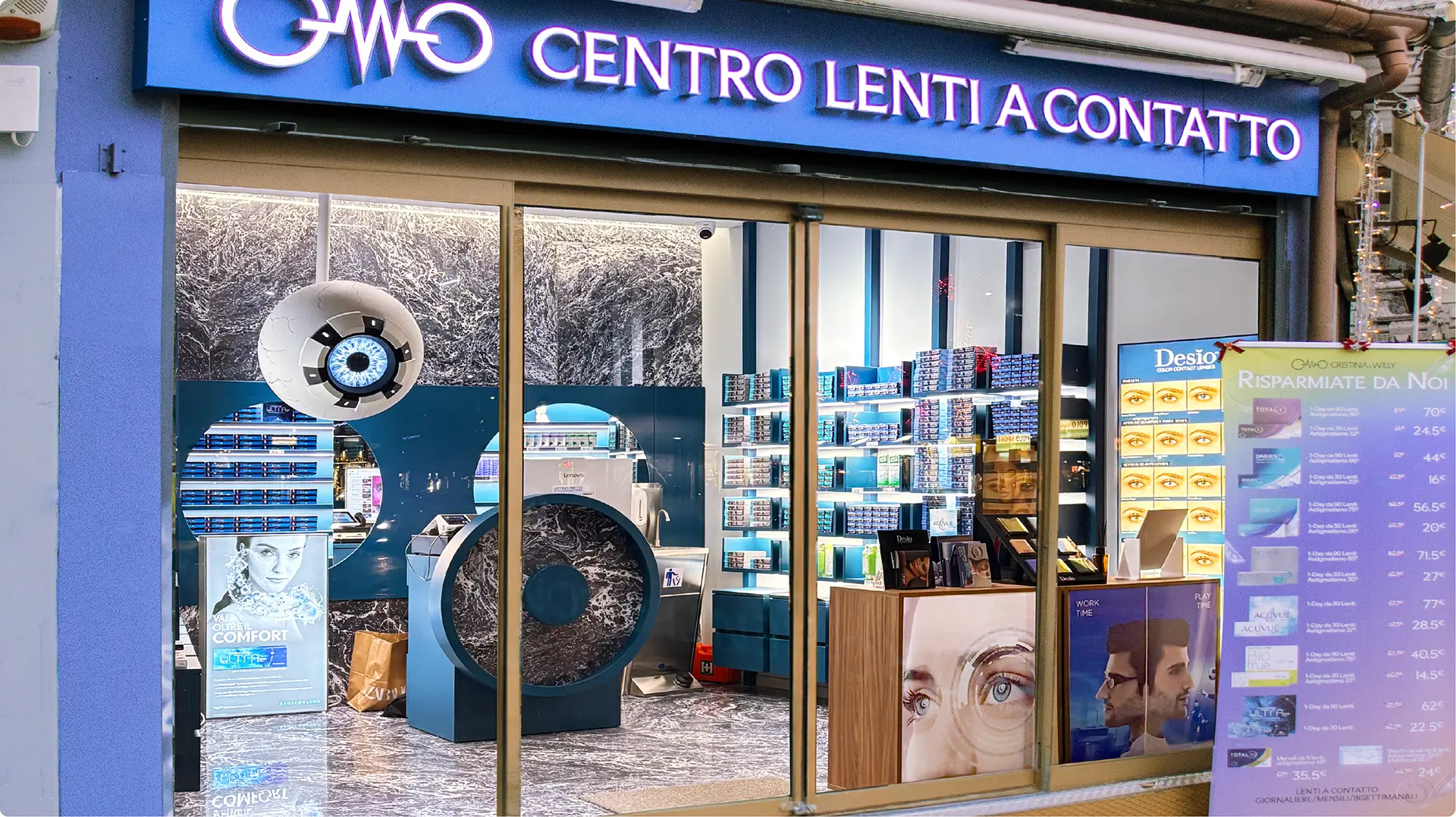 Scaffali celesti con esposizione lenti a contatto Milano dei brand Acuvue, Desio, Baush + Lomb